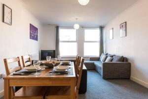 a dining room with a table and a couch at Old Town Apartments in Swindon