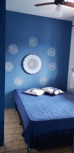 1 dormitorio azul con 1 cama con pared azul en Casa Miosótis apartamentos, en Palhoça