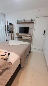1 dormitorio con 2 camas y TV en la pared en Meu Resort no Recreio - RJ, en Río de Janeiro