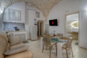 a kitchen and living room with a table and a couch at Home Pedra in Ceglie Messapica