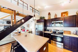 a kitchen with wooden cabinets and a spiral staircase at Shelburne Bay Stay & Play in South Burlington