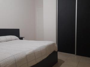 1 dormitorio con cama blanca y armario negro en Apart Soles II en Río Cuarto