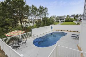ein Swimmingpool auf einer Terrasse mit einem weißen Zaun in der Unterkunft 39609 Waterworks Ct in Bethany Beach