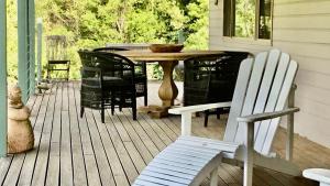 a wooden deck with a table and chairs on a porch at Grandmas Cottage Fairmont in Woodhill