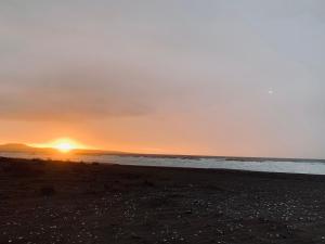una puesta de sol en la playa con el océano en el fondo en Cabañas ecológicas Tongoy, en Tongoy