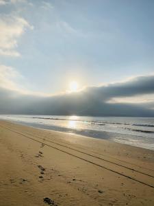 uma praia com o sol nascendo sobre o oceano em Cabañas ecológicas Tongoy em Tongoy
