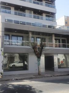 un árbol frente a un edificio con un coche en la ventana en Hermoso departamento boutique con pileta en Salta