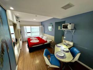 Habitación pequeña con cama roja y mesa. en HOTEL NAVEGANTES VISTA PARA MAR Boa Viagem en Recife