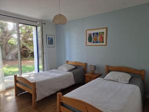 Duas camas num quarto com uma janela em Holiday home with sea view, Pordic em Pordic