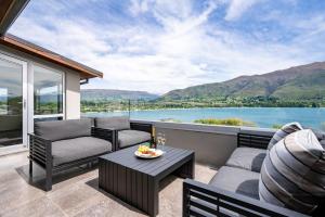a patio with a view of the water and mountains at Luxury Lakeview Vista Apartment in Wanaka