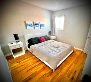 a bedroom with a large bed and a wooden floor at Modern Home Near Downtown in Denver