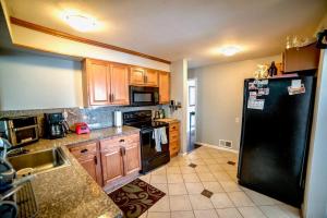 a kitchen with a black refrigerator and wooden cabinets at Modern Home Near Downtown in Denver