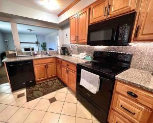 una cocina con electrodomésticos negros y armarios de madera en Modern Home Near Downtown en Denver