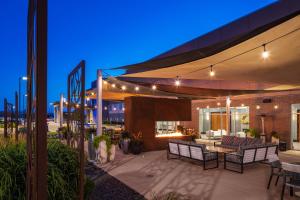 eine Terrasse mit Stühlen und Tischen unter einem Baldachin in der Nacht in der Unterkunft Holiday Inn Express & Suites Sioux City North - Event Center, an IHG Hotel in Dakota Dunes