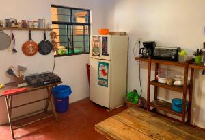 a kitchen with a white refrigerator in a room at Hostal 23 in San Cristóbal de Las Casas