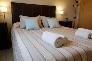 a bedroom with a large bed with towels on it at UBICACION PERFECTA Y CONFORT- 5TA SECCION in Mendoza +15 photos