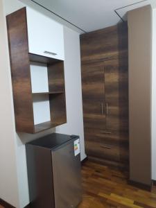 a kitchen with a refrigerator and wooden cabinets at Hotel Esmeralda in La Paz +75 photos
