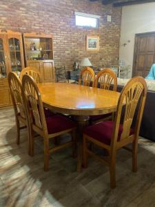 a wooden table and chairs with a kitchen in the background at NUESTRA CASA EN CHACRAS DE CORIA (Bª PRIVADO) in Chacras de Coria