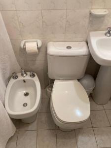 a white bathroom with a toilet and a sink at NUESTRA CASA EN CHACRAS DE CORIA (Bª PRIVADO) in Chacras de Coria