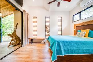 Schlafzimmer mit einem Bett mit blauer Decke in der Unterkunft La Casa Tico Tango in Playa Grande