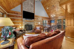 uma sala de estar com um sofá de couro e uma lareira em Casa Tweetsie em Banner Elk