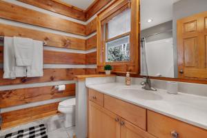 a bathroom with wooden walls and a sink and a toilet at Casa Tweetsie in Banner Elk +37 photos