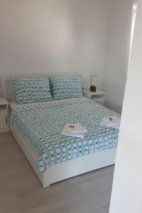 una camera con letto e lenzuola bianche e blu di Apartments by the sea Jadrija, Sibenik - 18976 a Vodice