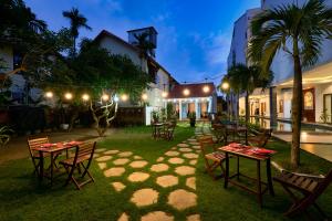 un grupo de mesas y sillas en un patio por la noche en Legend Oasis Hoi An Boutique Hotel, en Hoi An