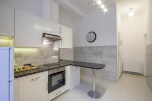 cocina con encimera y reloj en la pared en City Centre Apartment with 3 Bathrooms, en Budapest
