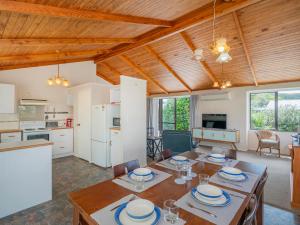 a kitchen and dining room with a table and chairs at Treasure on Chestnut - Tairua Holiday Home in Tairua