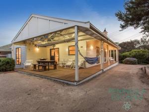 Una casa con una gran terraza con una hamaca. en Portsea Essential, en Portsea