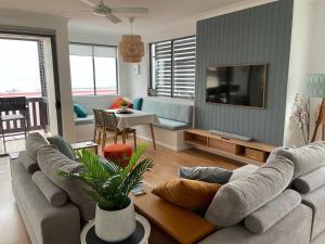 a living room with a couch and a tv at Coolum Beach Resort in Coolum Beach