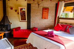 a bedroom with a large bed and a fireplace at Pousada Chalé Sol Nascente in Santo Antônio do Pinhal