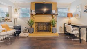 a living room with a fireplace with a flat screen tv at King bed open floorplan in heart of Bham in Birmingham
