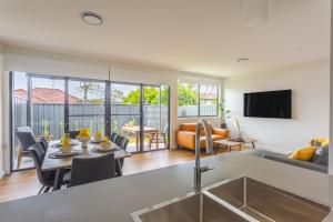 cocina y sala de estar con fregadero y mesa en Chapel Heights Apartments, en New Lambton