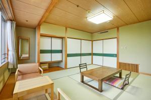 - un salon avec une table et une chaise dans l'établissement KAMENOI HOTEL Kitsuregawa, à Sakura