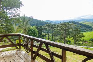 a wooden deck with a view of the mountains at Pousada Chalé Sol Nascente in Santo Antônio do Pinhal