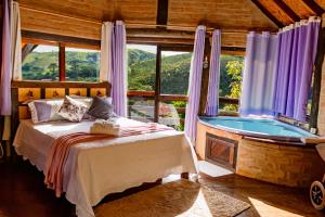 a bedroom with a bed and a tub in a room at Pousada Chalé Sol Nascente in Santo Antônio do Pinhal
