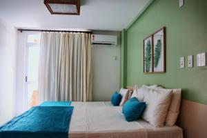 Schlafzimmer mit einem Bett mit blauen und weißen Kissen in der Unterkunft Grand Lençóis Flat in Barreirinhas