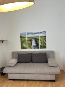 a living room with a couch and two paintings on the wall at Prater Tree big 3 room apartment near Innere Stadt in Vienna