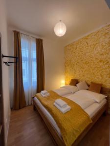 a bedroom with a large bed with a yellow blanket at Prater Tree big 3 room apartment near Innere Stadt in Vienna