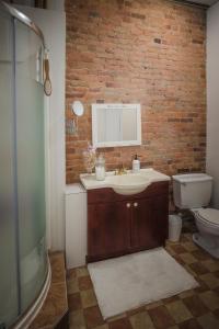 a bathroom with a sink and a brick wall at Le 402 in Montréal