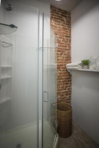 y baño con ducha de cristal y pared de ladrillo. en Le 402, en Montreal