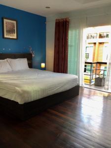 a bedroom with a bed with a blue wall at Wonderful Pool House at Kata in Kata Beach