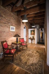 a living room with chairs and a table and a brick wall at Le 402 in Montréal