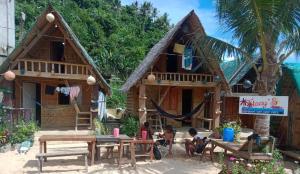 a group of children sitting in front of a house at Titaays Surfers Inn in Baras