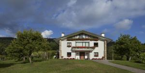 a white house with a flower box on the front at Basarte Cottage in Bakio