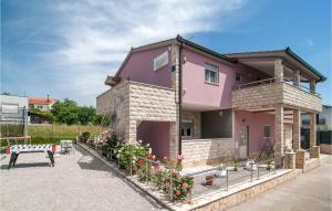 ein rosa Haus mit einem Zaun davor in der Unterkunft Stunning Home In Hrvace With Heated Swimming Pool in Hrvace