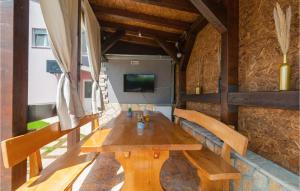 einen Holztisch und Stühle in einem Zimmer mit einem TV in der Unterkunft Stunning Home In Hrvace With Heated Swimming Pool in Hrvace