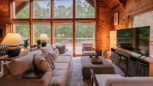 sala de estar con sofá grande y TV en Amenity Packed A-frame Cabin With Two Bedrooms And Loft, en Gainesville